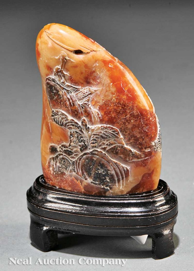 Chinese Soapstone Pebble: A Chinese Soapstone Pebble, carved to one side with two figures seated beneath a tall pine tree, inscribed, the other side carved with plantains and rocks, height 3 3/4 in., width 2 1/2 in., wood stan