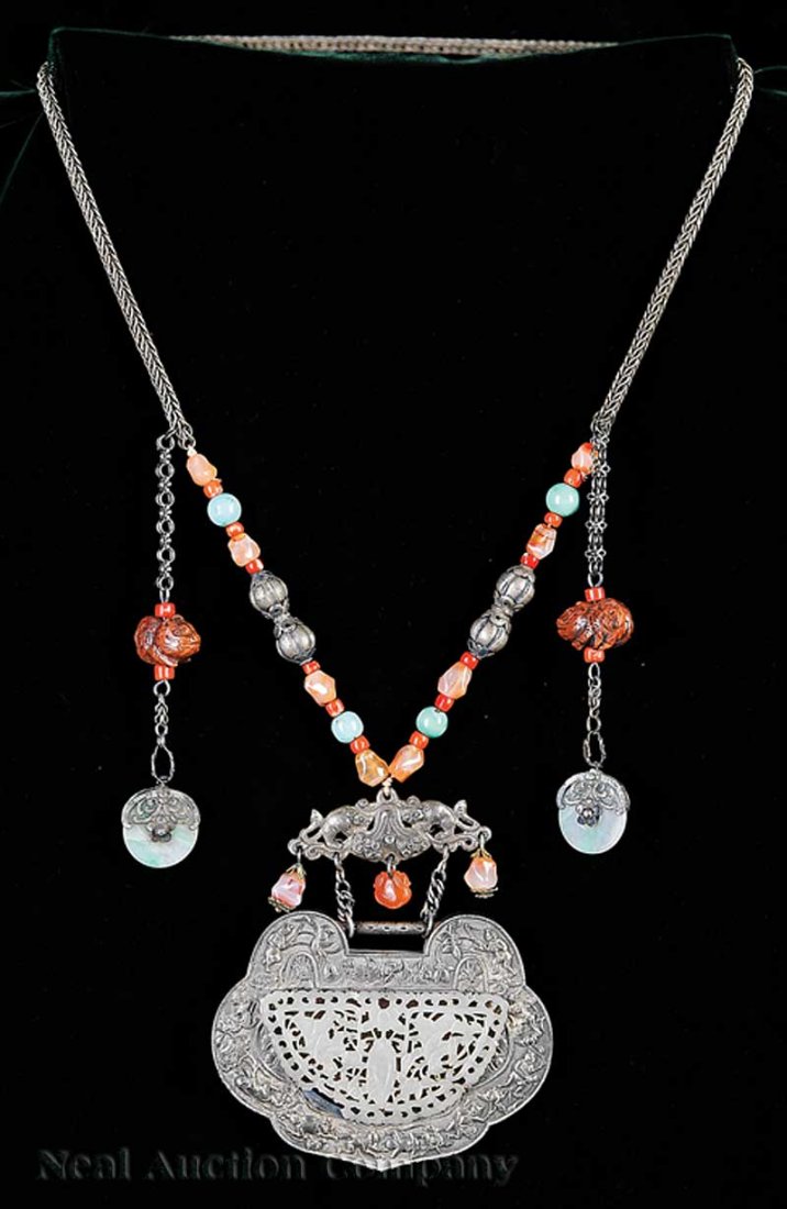 Sino-Tibetan Jade Inset Gua Pendant/Necklace: A Sino-Tibetan Jade Inset White Metal Gua Pendant-Hung Necklace, 19th c., the prayer box of lobed ruyi form repousse decorated with boys at play amid bats and lotus, inset with a reticulated crescent 