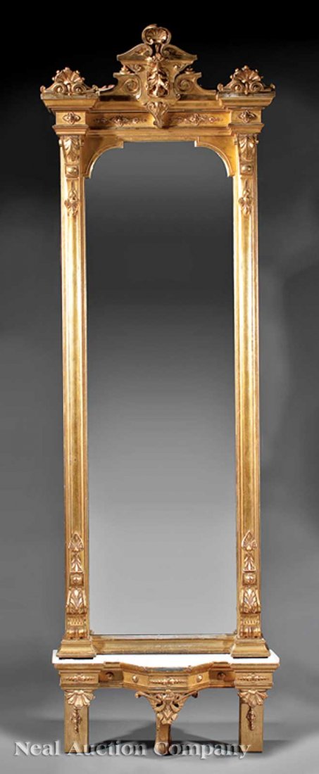 Carved and Gilded Pier Mirror: An American Renaissance Carved and Gilded Pier Mirror, c. 1870, anthemion and shell crest, blocked corners, strapwork sides, shaped mirror plate with conforming marble top base, anthemion supports, he