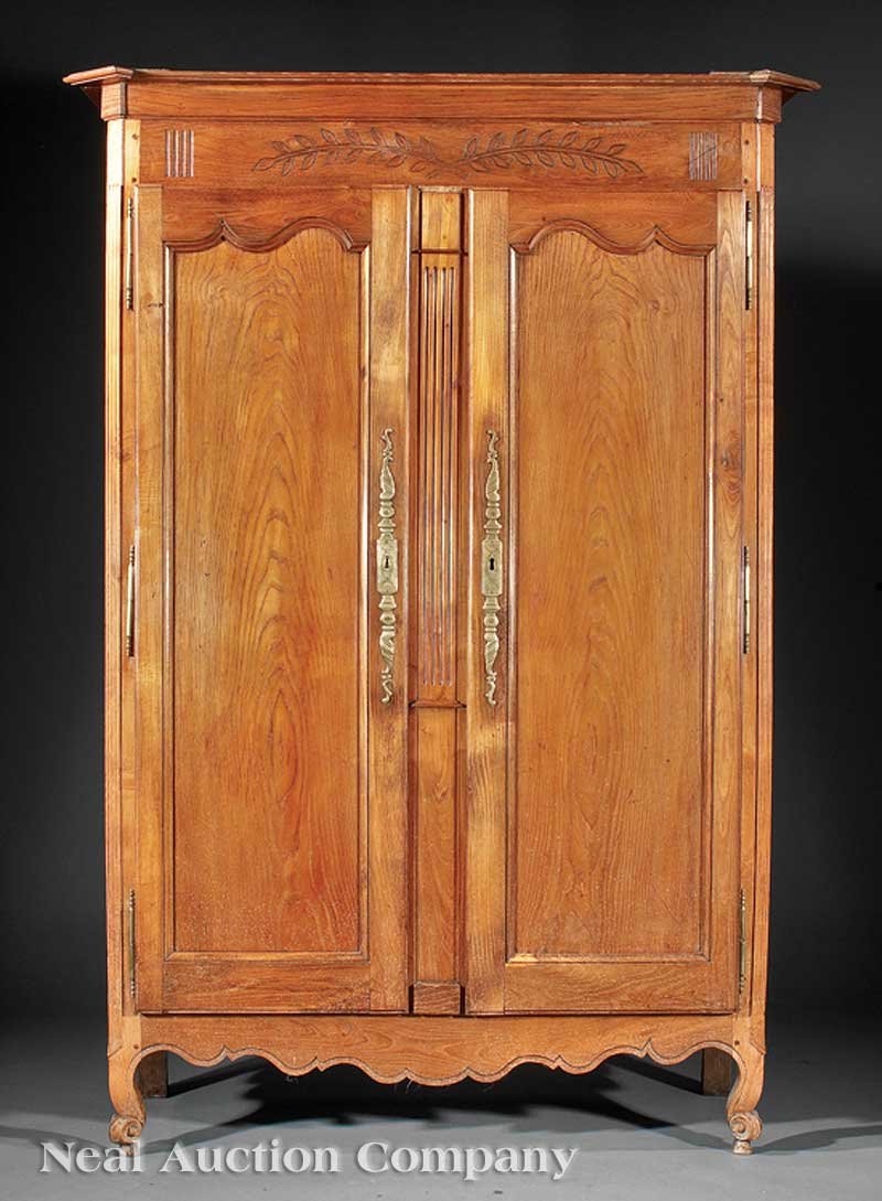 French Provincial Carved Oak Armoire: A French Provincial Carved Oak Armoire, cornice with canted corners, conforming case, paneled doors, shelf interior, fiche hinges, scrolled feet, height 86 in., width 61 in., depth 25 in