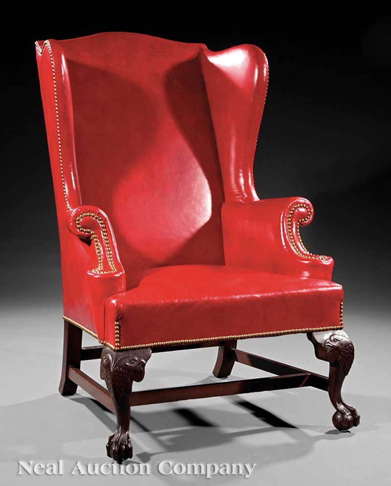 American Carved Mahogany Wing Chair: An Antique American Carved Mahogany Wing Chair, serpentine back, scrolled arms, red leather upholstery with brass nailhead trim, eagle head cabriole legs ending in ball and claw feet joined by stretch
