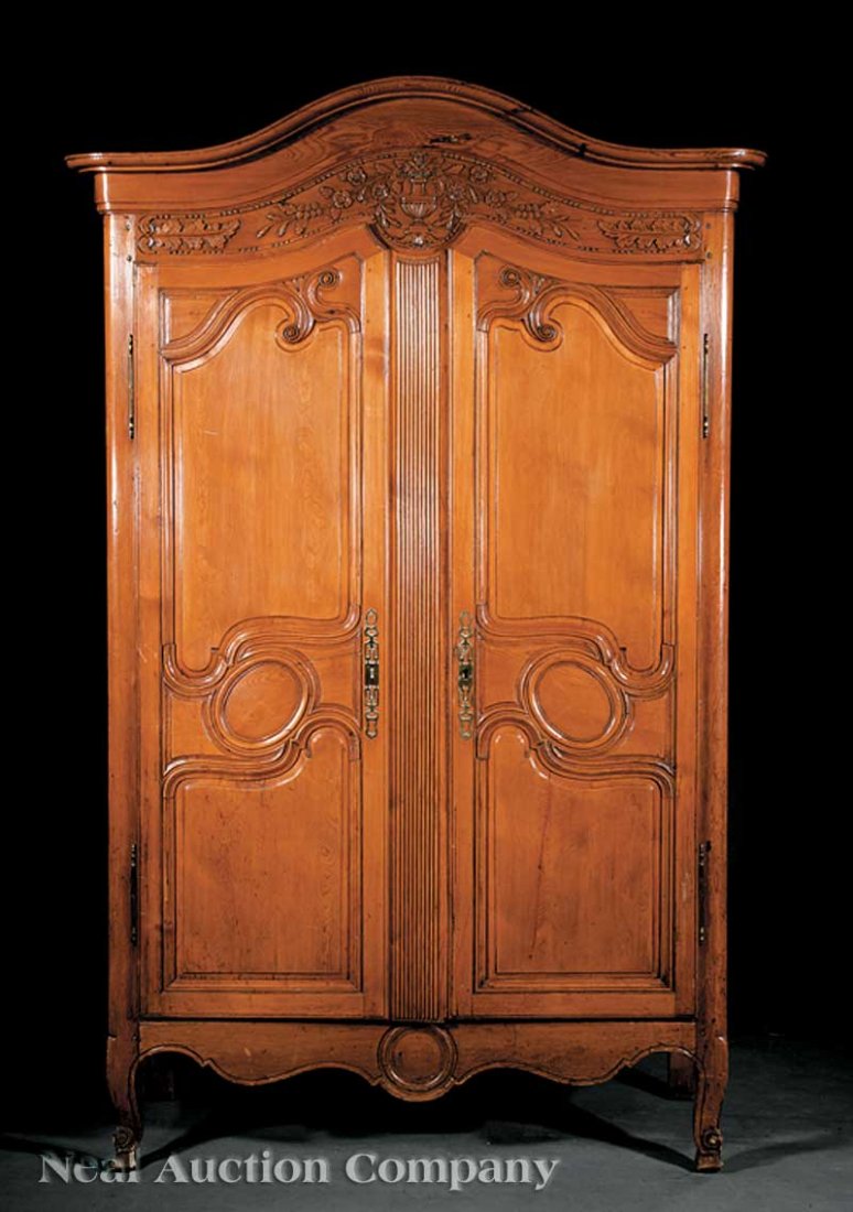 Louis XV Carved Pine Armoire: A Louis XV Carved Pine Armoire, late 18th/early 19th c., arched cornice, frieze with flower-filled urn and beaded molding, arched raised panel doors with volute moldings, reeded center stile, shaped s