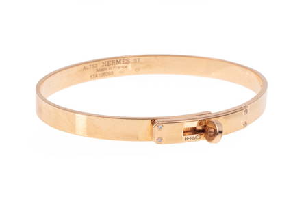 Hermès 18 kt. Yellow Gold and Diamond Bracelet: Hermès 18 kt. Yellow Gold and Diamond "Kelly" Bangle Bracelet, clasp marked "HERMES - PARIS", interior marked "Au7050 HERMES ST", "Made in France" and "17A106095", set with 4 diamonds, inner circ