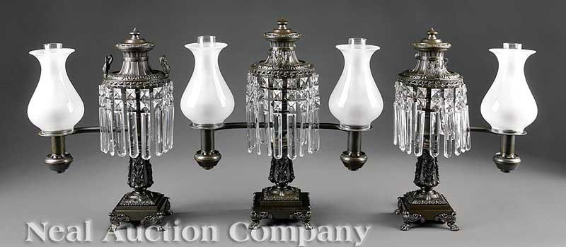 Bronze Argand Garniture, poss. Louis Veron & Co.: An American Patinated Bronze Argand Garniture, mid-19th c., possibly Louis Veron & Co., Philadelphia, consisting of a double arm flanked by single arms, each molded urn form font with prism ring toppe