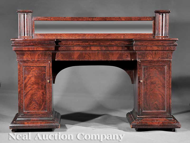 Carved Mahogany Pedestal Sideboard: An American Restauration Carved Mahogany Pedestal Sideboard, early 19th c., in the manner of Duncan Phyfe, top with a mirrored backsplash flanked by blocked pilasters, stepped frieze above blind long