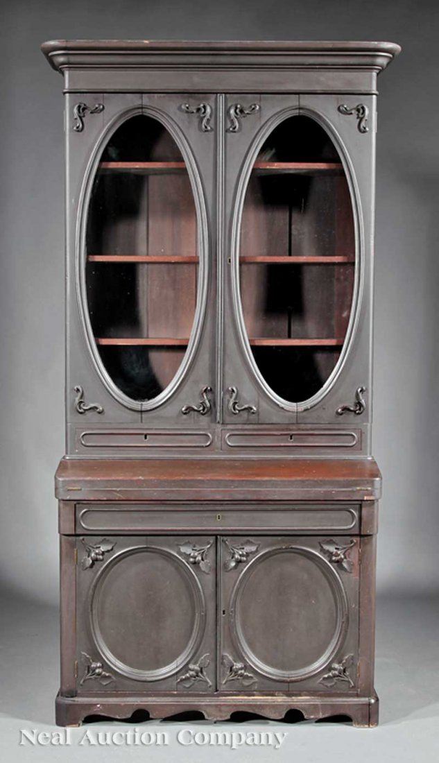 Rosewood-Grained Mahogany Secretary-Bookcase: An American Rococo Carved and Rosewood-Grained Mahogany Secretary-Bookcase, mid-19th c., probably Southern, molded cornice, oval glazed doors, shelf interior, foldover writing surface, long drawer and