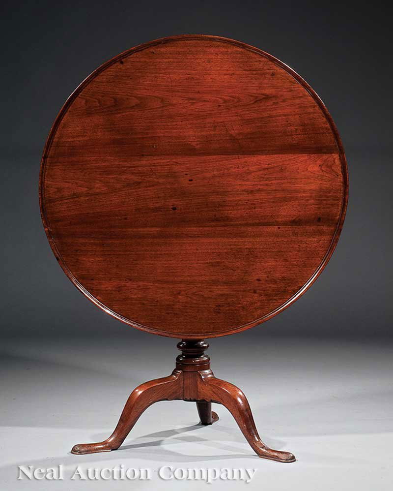 Georgian Carved Mahogany Tilt-Top Tea Table: A Georgian Carved Mahogany Tilt-Top Tea Table, 18th c., top with molded edge, birdcage support, baluster stem, arched legs ending in pad feet, height 28 in., diameter 34 3/4 in