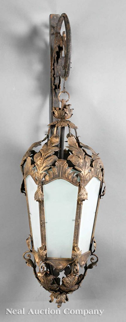 Rococo-Style Wrought Iron and Tole Lanterns: A Pair of Rococo-Style Wrought Iron and Tole Lanterns, hexagonal with foliate decoration, inset with opaque glass panels, scrolled brackets, height 53 in., width 16 in., depth 16 in