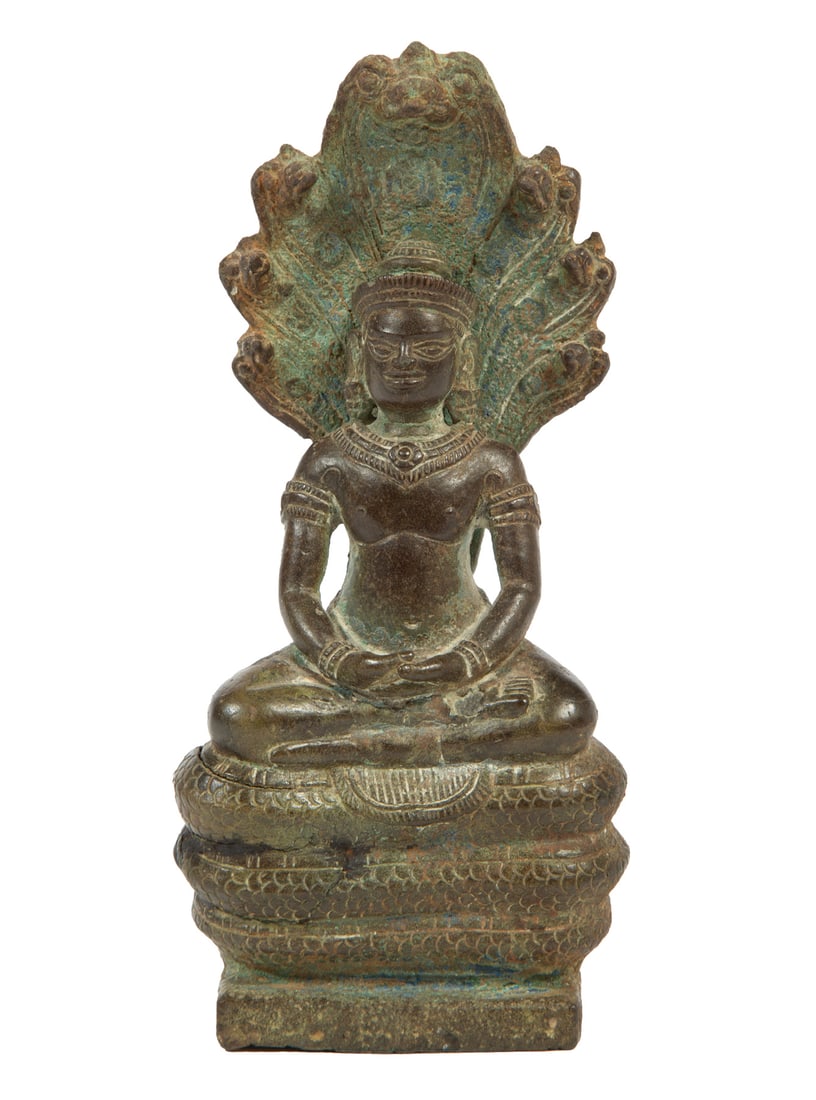 Khmer Bronze Figure of the Buddha Muchalinda: Khmer Bronze Figure of the Buddha Muchalinda, modeled seated in dhyanasana atop a coiled cobra, wearing a headdress and body jewelry before a seven-headed cobra mandorla, h. 6 1/2 in. Provenance: The
