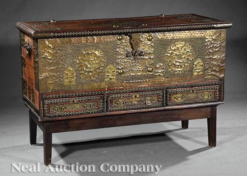 An Antique Indo-African Hardwood "Treasure" Chest: An Antique Indo-African Brass-Mounted Hardwood "Treasure" Chest, Zanzibar, rectangular trunk over three frieze drawers, hinged lid opening to fitted interior, exterior embellished with pierced brass p