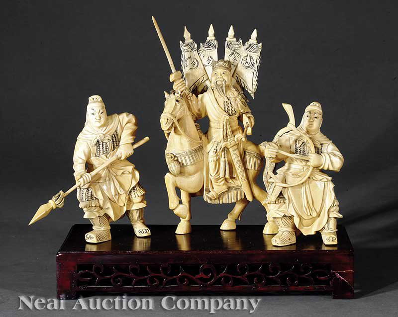 Three Chinese Ivory Figures of Warriors: A Set of Three Chinese Ivory Figures of Warriors, the central figure carved seated astride a horse bearing multiple flags on his back and carrying a sword in one hand and a spear in the other, height