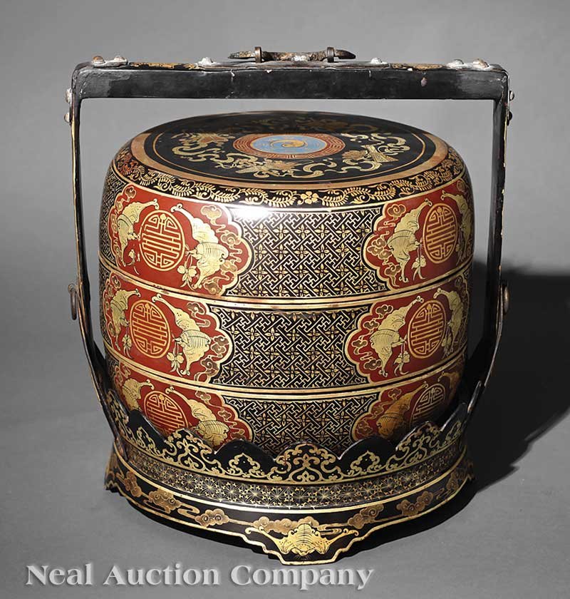 A Chinese Lacquer Stacking Box: A Chinese Polychrome and Gilt Lacquer Stacking Box and Carrying Case, two-tiered circular box and cover decorated around the sides with shaped cartouches enclosing bats and shou, the cover with a ying