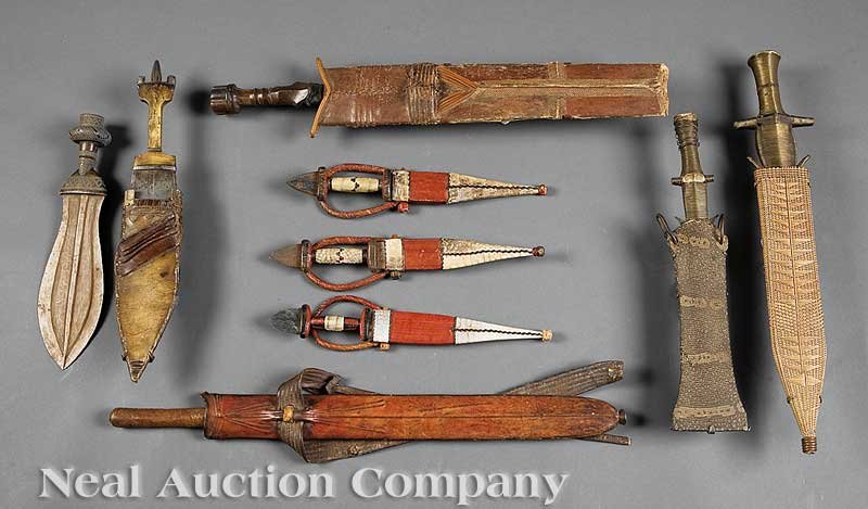 A of Nine African Weapons: A Collection of Nine African Weapons, including two Fang iron knives with wire banding in sheaths; a Kiba ikul with copper blade; a Salampasu sword with scabbard; three Tuareg knives with leather and 