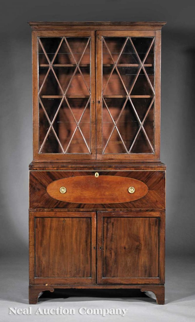 A George III Mahogany Inlaid Secretary Bookcase: A George III Mahogany Inlaid Secretary Bookcase, c. 1790, flared cornice over glazed doors enclosing shelves; lower case with fall front escritoire drawer opening to well-fitted interior, over paneled