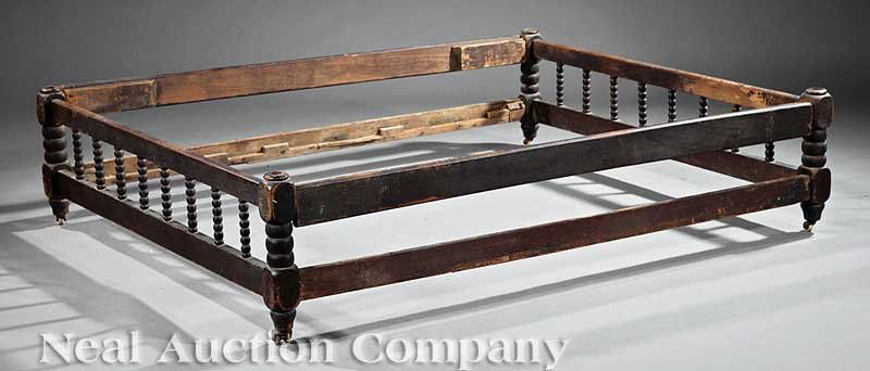 An Antique Trundle Bed: An Antique Trundle Bed, spool head and foot rails, plain side rails, casters, height 14 in., length 57 in., width 46 in Provenance: The Barrow/Brandon/Bedgood House at Greenwood Plantation, Pickneyvil