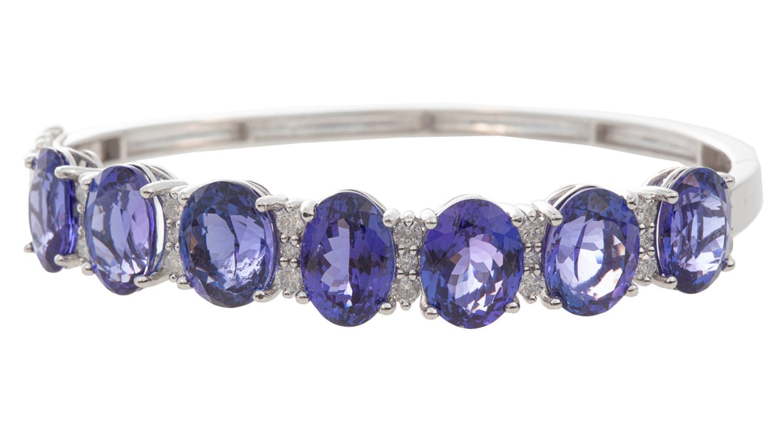 Platinum, Tanzanite and Diamond Hinged Bangle Bracelet: , 7 modified brilliant cut pavilion tanzanite, total wt. approx. 28.39 cts.; accented with 24 round brilliant cut diamonds, total wt. approx. 1.17 cts.; inner circ. 7 in.; AIGL report.Please note: Pay