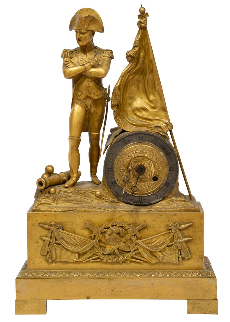 Napoleon III Gilt Bronze "Napoleon" Mantel Clock h. 14 3/4 in., w. 9 3/4 in., d. 3 1/2 in.: Napoleon III Gilt Bronze "Napoleon" Mantel Clock, 19th c., silk-thread striking bell movement, the figure standing beside a flag and cannon, h. 14 3/4 in., w. 9 3/4 in., d. 3 1/2 in.h. 14 3/