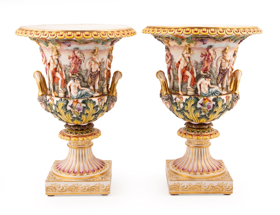 Pair of Capodimonte Porcelain Urns h. 19 1/4 in., dia. 13 1/2 in.: Pair of Capodimonte Porcelain Urns , marked, double-mask handles, frieze of Classical figures, h. 19 1/4 in., dia. 13 1/2 in. h. 19 1/4 in., dia. 13 1/2 in.