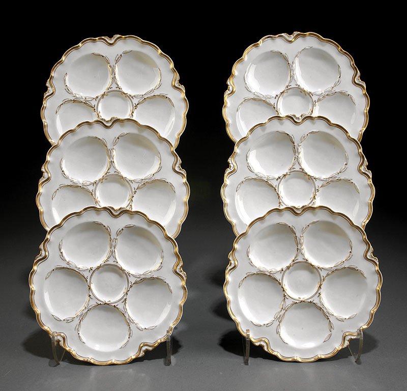 Six Limoges Porcelain Oyster Plates: A Set of Six Limoges Porcelain Oyster Plates, with five wells for oysters and one central well for condiments, gilt laurel wreath decoration, diameter 9 in.; together with 12 Wedgwood creamware "Leaf"
