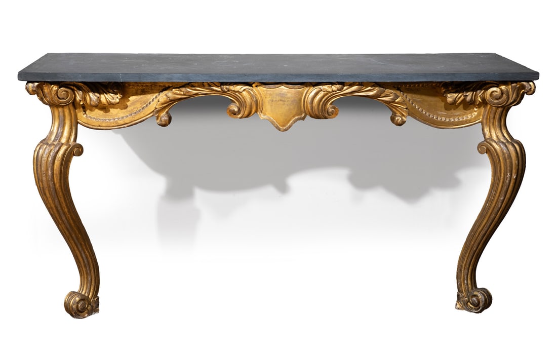 Italian Rococo Carved Giltwood Console: Italian Rococo Carved Giltwood Console, late 18th / early 19th c., slate top, foliate and scrolled carved frieze centered by a shield, scrolled lobed cabriole legs, h. 34 1/2 in., w. 66 in., d. 24 in.