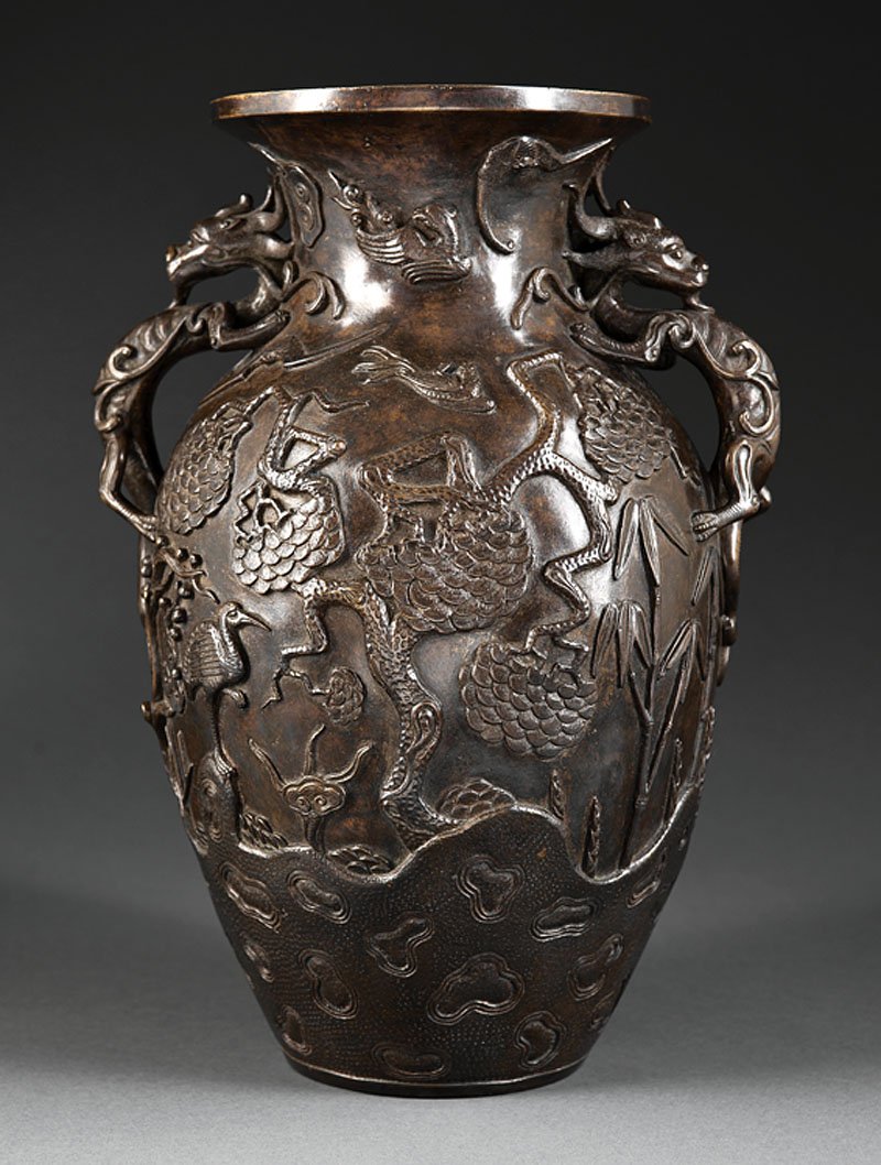 A Chinese or Japanese Bronze Vase: A Chinese or Japanese Bronze Vase, probably 18th c., baluster form with dragon handles, cast in relief with the Three Friends of Winter with phoenix, parrots, bats and crane above rockwork, base with 