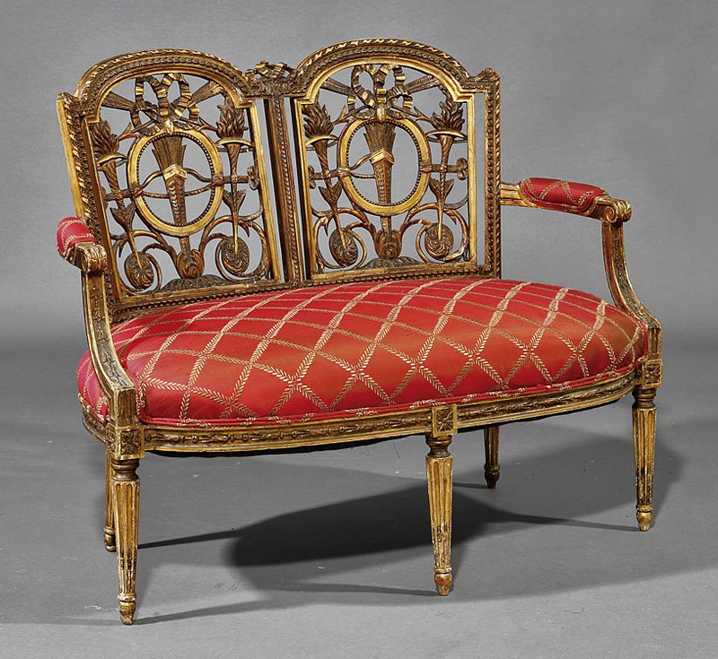 An Italian Neoclassical Carved Giltwood Settee: An Italian Neoclassical Carved Giltwood Settee, early 19th c., guilloche molded crest rail, beribboned arrow quiver and torch pierced back, shaped padded arms, rounded seat rail, fluted tapered legs, 