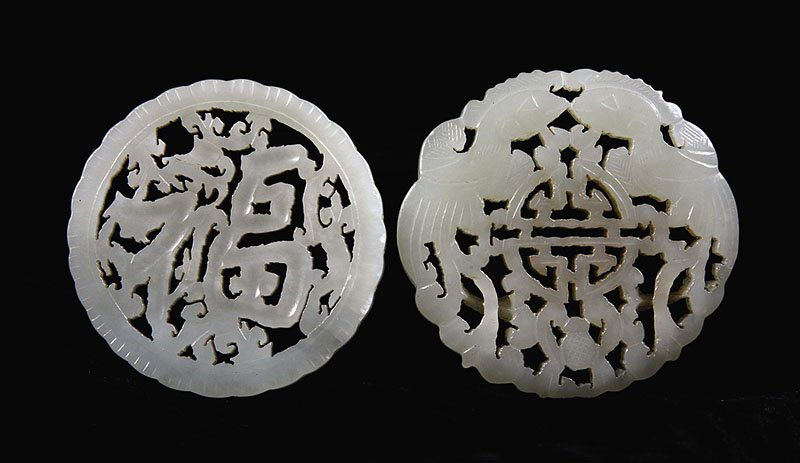 Two Chinese Pale Celadon Jade Circular Plaques: Two Chinese Pale Celadon Jade Circular Plaques, the first carved and pierced with Chinese characters, the second with phoenix birds and a Shou character, diameter 2 in