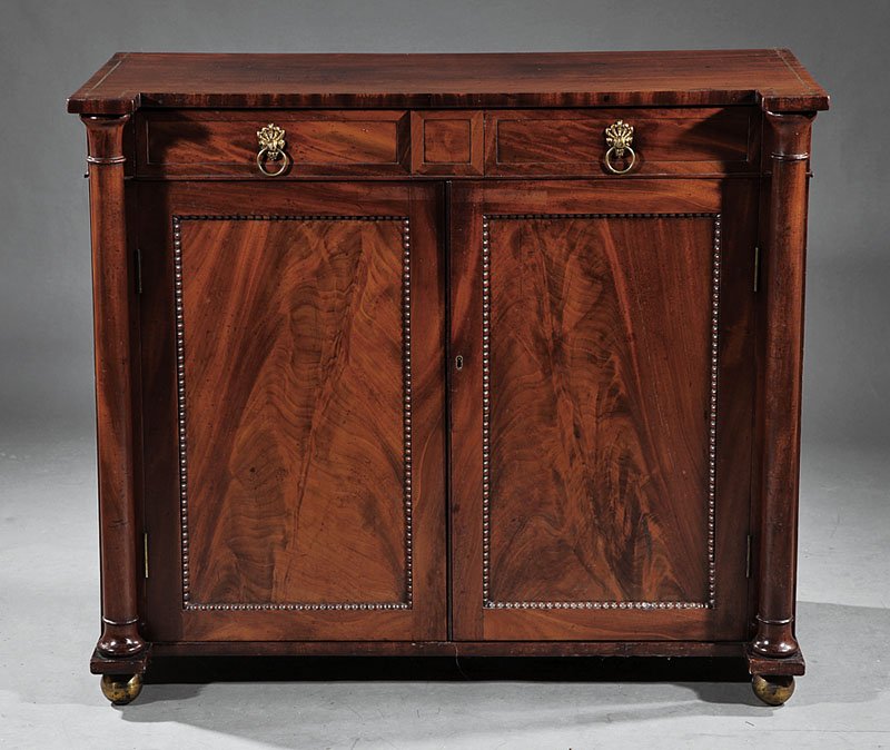 A William IV Carved Mahogany Server: A William IV Carved Mahogany Server, early 19th c., paneled drawers over beaded paneled doors, flanked by colonnettes, ball feet, height 35 1/4 in., width 41 1/2 in., depth 20 3/4 in