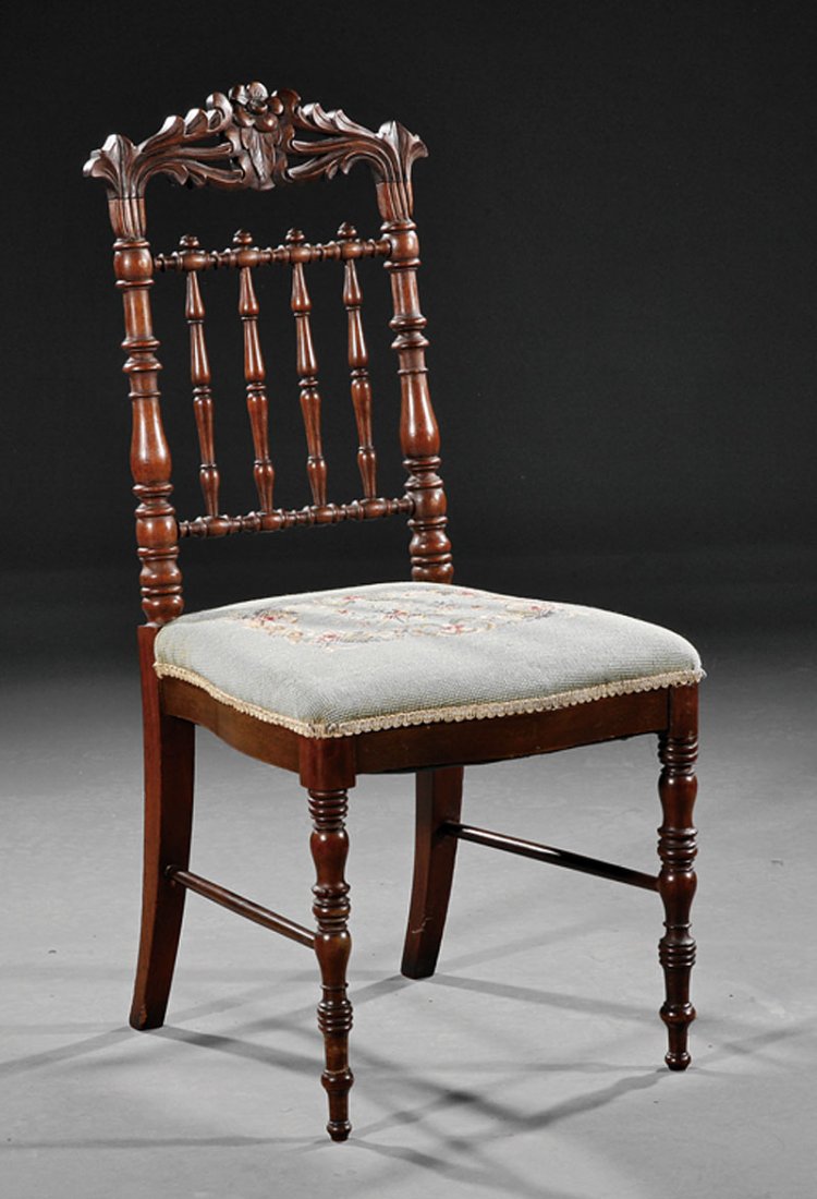 An American Carved Walnut Child's Parlor Chair: An American Carved Walnut Child's Parlor Chair, mid-19th c., floral and foliate crest rail, spindle back, floral needlepoint seat, turned legs