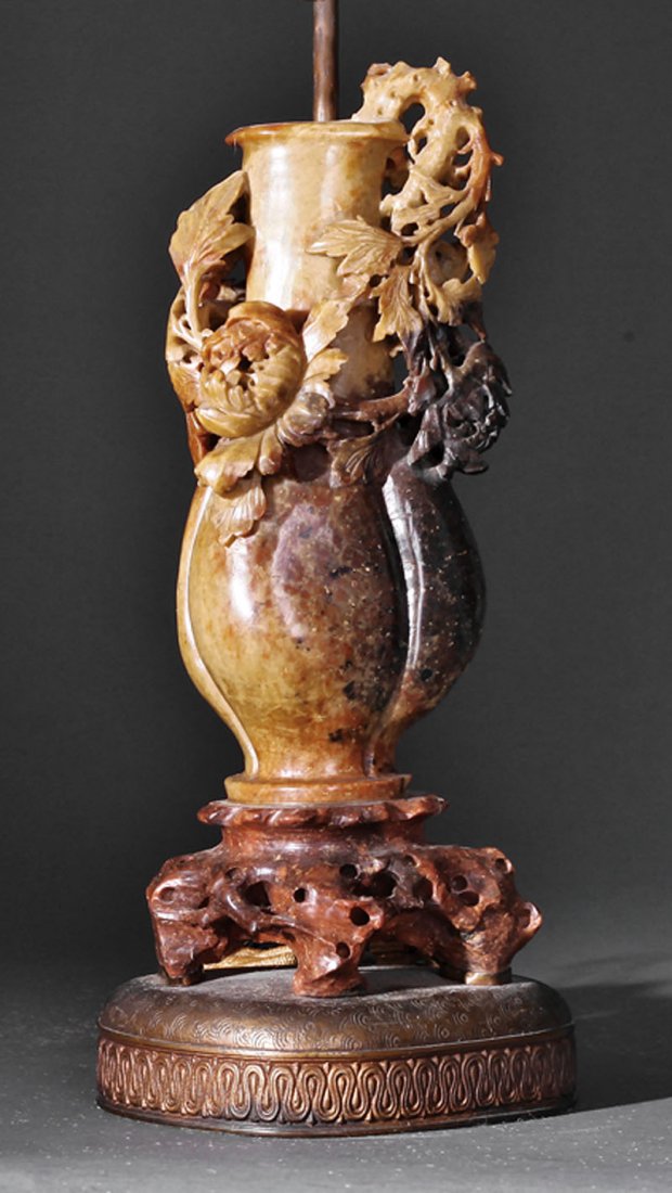 A Chinese Soapstone Bottle Vase: A Chinese Soapstone Bottle Vase, lobed globular body and tall neck carved with entwined peony sprays, raised on a naturalistic rockwork base, height 11 in., now mounted to a stand as a lamp