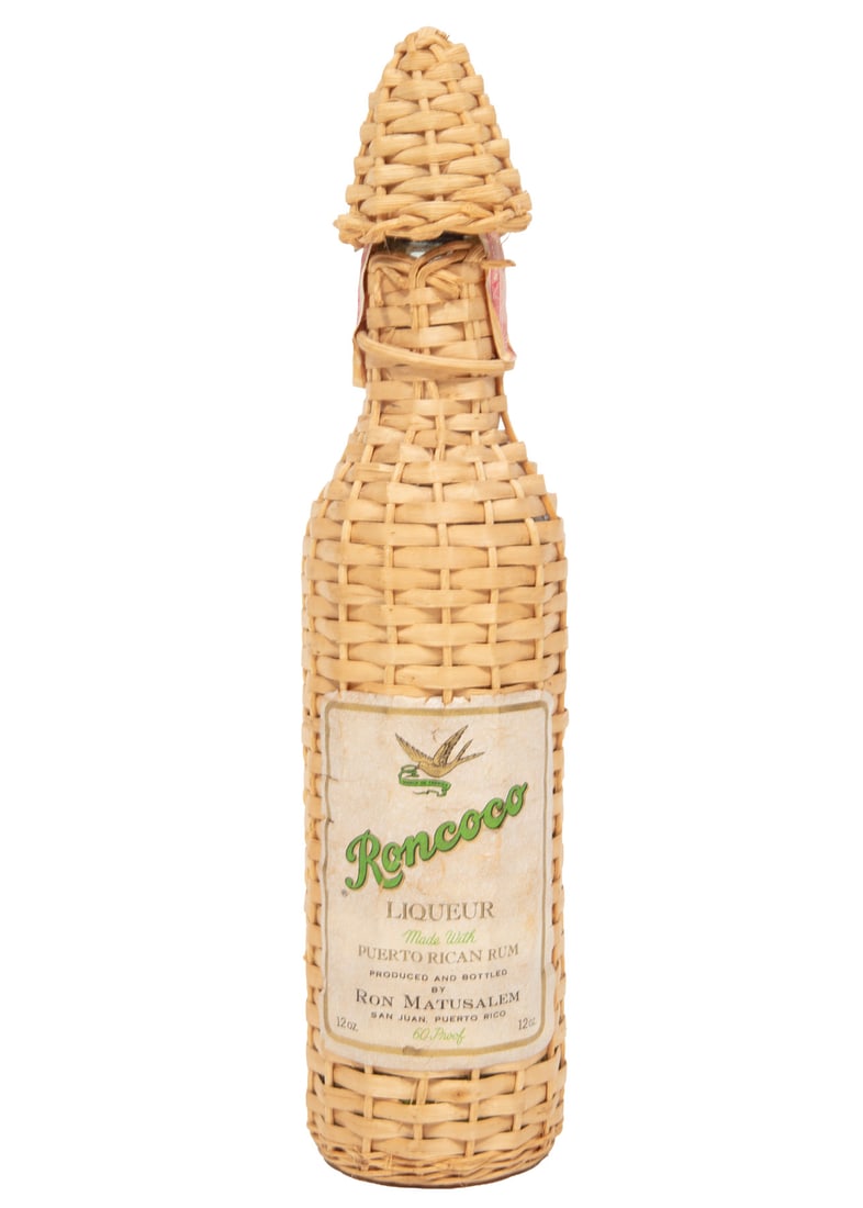 Ron Matusalem Roncoco Liqueur: Ron Matusalem Roncoco Liqueur1 bottle, 12 oz., bottled c. 1975-1977, 60 proof, red tax strip, with original wicker wrapping, wicker cap and wood underside.Provenance: Estate of Mr. & Mrs. Jacob Cohen,