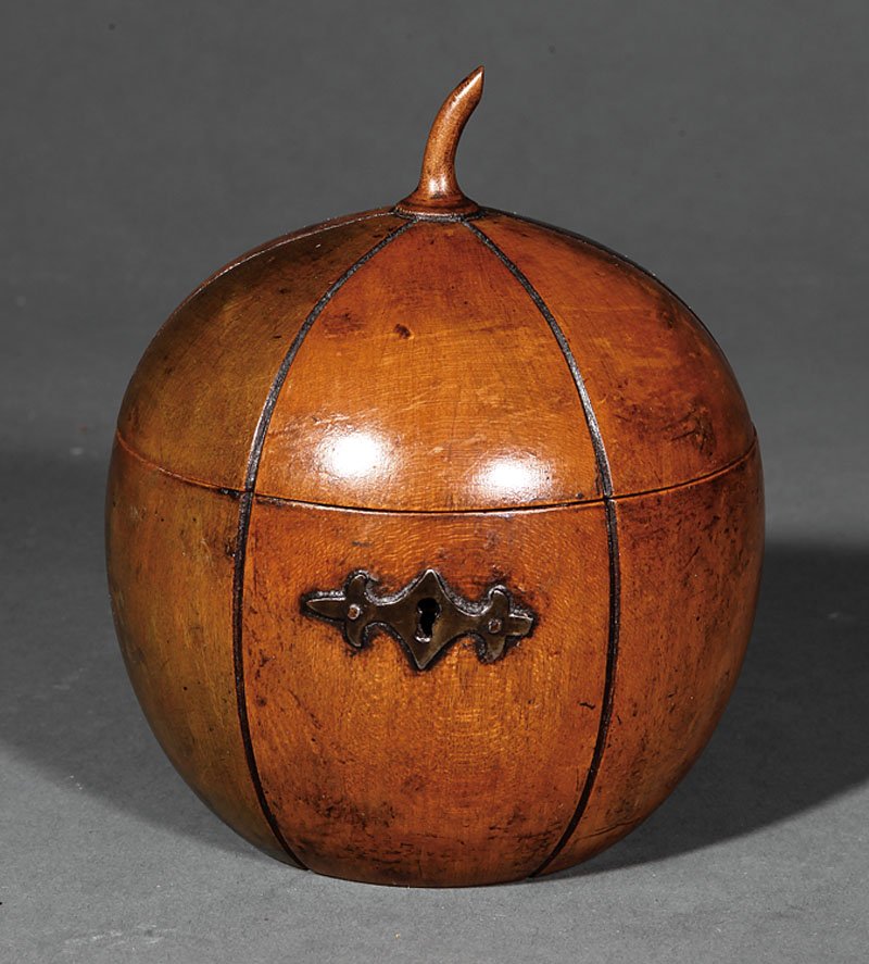George III Fruitwood Melon-Form Tea Caddy: A George III Fruitwood Melon-Form Tea Caddy, c. 1790, with stained panels and shaped escutcheon, interior retains traces of foil lining, height 5 3/4 in., diameter 5 in. Provenance: Lynda Willauer Ant