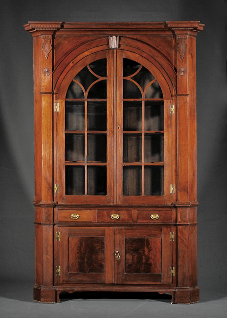 American Chippendale Walnut Corner Cupboard: An American Chippendale Carved Walnut Corner Cupboard, late 18th c., Pennsylvania, upper case with molded cornice over arched glazed doors with H hinges; lower case with three drawers above a pair of 