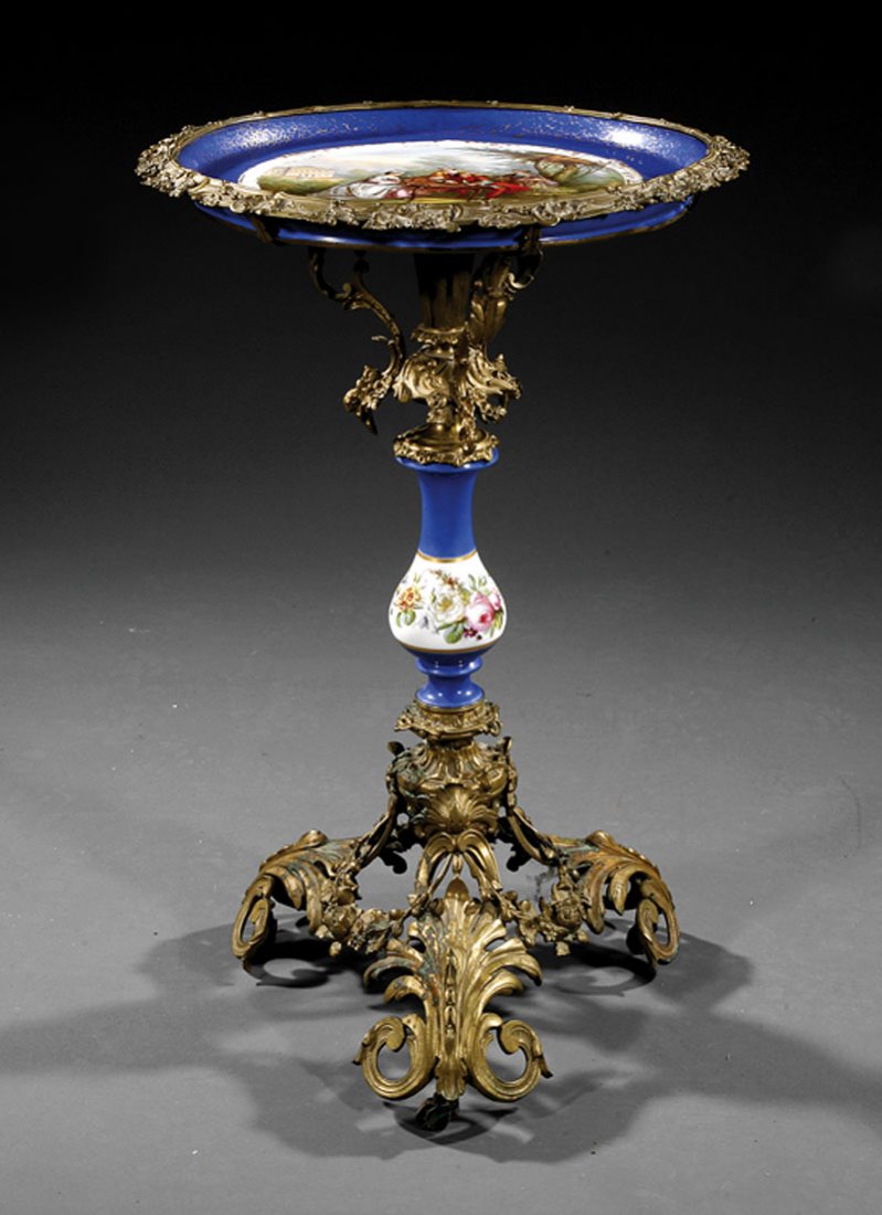 Gilt Bronze and "Sevres" Porcelain Gueridon: A Louis XVI-Style Gilt Bronze and "Sevres" Porcelain Gueridon, dished top with reserve of courtiers playing a game of chance, foliate edge, scrolled supports and vasiform stem, scrolled acanthus legs,