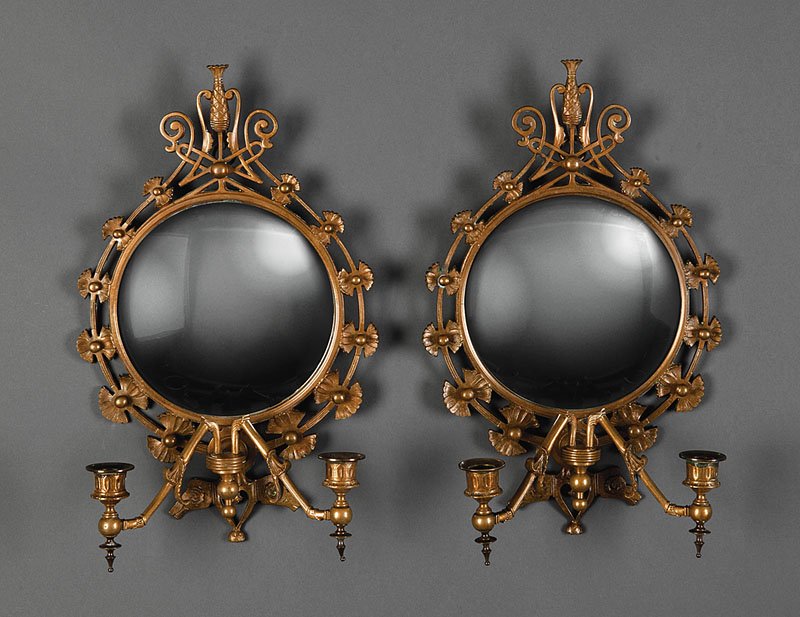 English Aesthetic Gilt Bronze Mirrored Sconces: A Pair of English Aesthetic Gilt Bronze Mirrored Sconces, late 19th/early 20th c., each convex mirror plate within floral surround, openwork crest with urn finial, two foliate candle arms, urn form ca