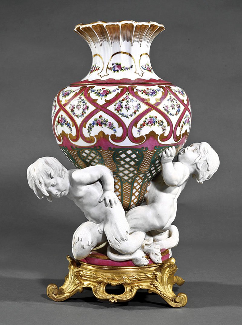 Gilt, Polychrome, Biscuit Porcelain Figural Vase: A French Gilt, Polychrome and Biscuit Porcelain Figural Vase, late 19th/early 20th c., bears Sevres mark, baluster body on mermen support, circular gilt bronze base, scrolled acanthus feet, height 17 
