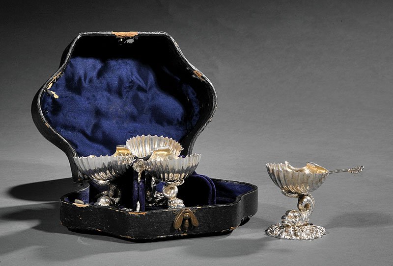 Four Continental Silverplate Figural Salts: A Cased Set of Four Continental Silverplate Figural Salts, each in the form of a shell on a dolphin support, in original fitted case with salt spoons, height 2 1/2 in