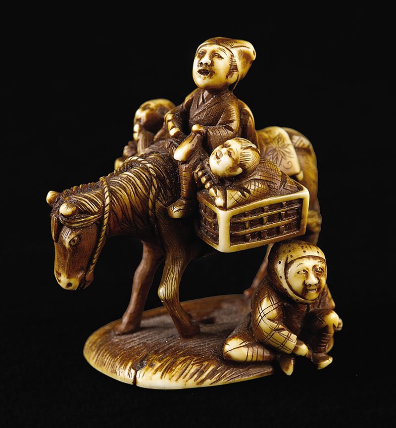 Japanese Stained Ivory Figural "Platform" Netsuke: A Japanese Stained Ivory Figural "Platform" Netsuke, probably Meiji Period (1868-1912), carved as horse bearing a rider seated between two saddle bags bearing further passengers, with a figure seated 