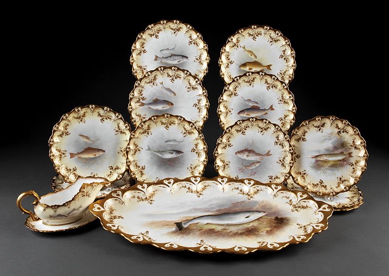An English Gilt and Polychrome Porcelain Fish Service: An English Gilt and Polychrome Porcelain Fish Service, c. 1900, marked Doulton Burlsem, comprising a fish platter, sauceboat with undertray, and 12 scalloped plates, plate diameter 8 3/4 in., platter 