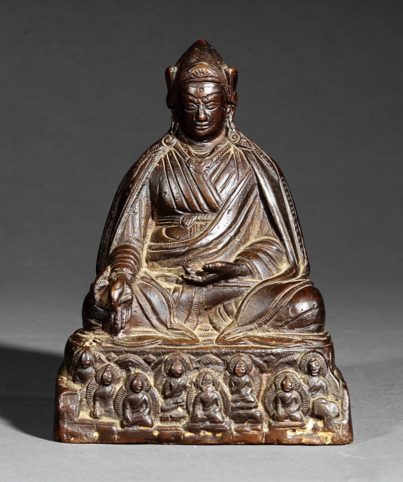 A Sino-Tibetan Bronze Figure of a Monk: A Sino-Tibetan Bronze Figure of a Monk, cast seated in dhyanasana upon a rectangular plinth with Buddhist figures in relief, height 6 1/4 in., width 4 1/2 in., depth 3 1/4 in
