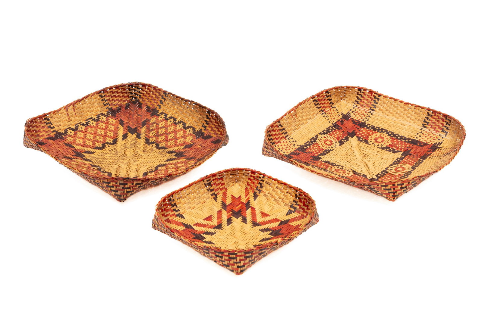 Three Chitimacha Single Weave Basket Trays: Three Chitimacha Single Weave Basket Trays natural, red, and black river cane; featuring "Blackbird?s Eye" and "Bull?s Eye" patterns. largest h. 3 in., w. 13 in., d. 13 1/2 in.; dimensions variable