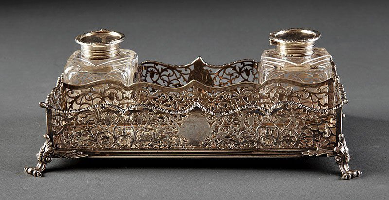 Sterling Silver Standish, George Fox, London: An English Sterling Silver Standish, George Fox, London, 1884, mark registered 1861; stand with reticulated gallery, scrolled gadroon crest and scrolled feet with foliate brackets, fitted with two bot