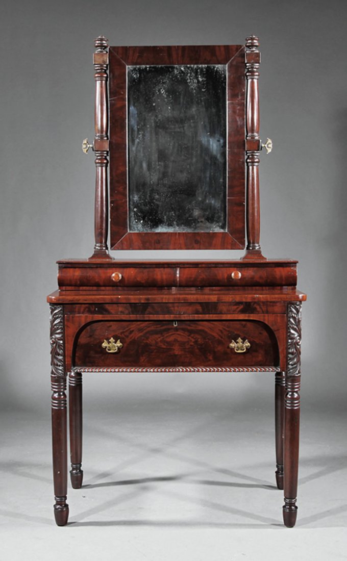 An American Classical Mahogany Dressing Bureau: An American Classical Carved Mahogany Dressing Bureau, c. 1830, New York, rectangular mirror, turned uprights, two drawer superstructure, arched paneled and gadrooned drawer, acanthus corners, turned 