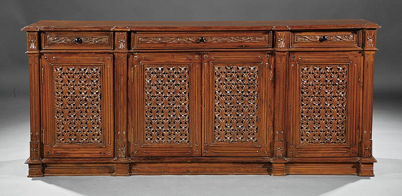 An Italian Carved Walnut Credenza: An Italian Carved Walnut Credenza, molded top, three frieze drawers over paneled pierced foliate doors, plinth base, height 30 1/2 in., width 71 in., depth 17 1/2 in