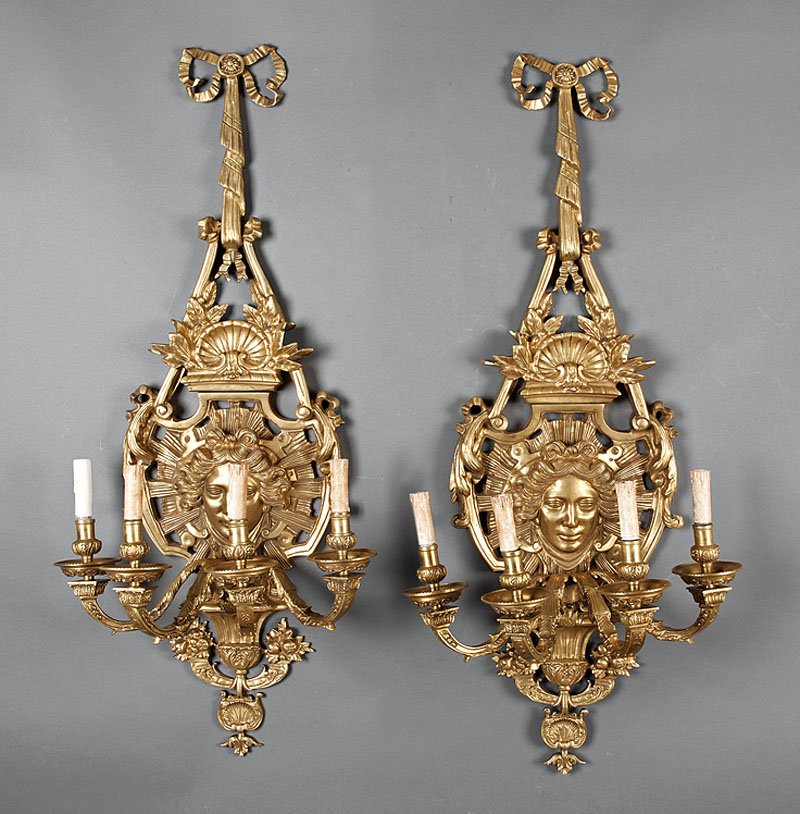 A Pair of Regence-Style Gilt Bronze Four-Light Wa: A Pair of Regence-Style Gilt Bronze Four-Light Wall Sconces, 19th c., bows and ribbons supporting shell-surmounted shield with radiant masks issuing foliate candle arms, height 43 1/2 in., width 19 1/