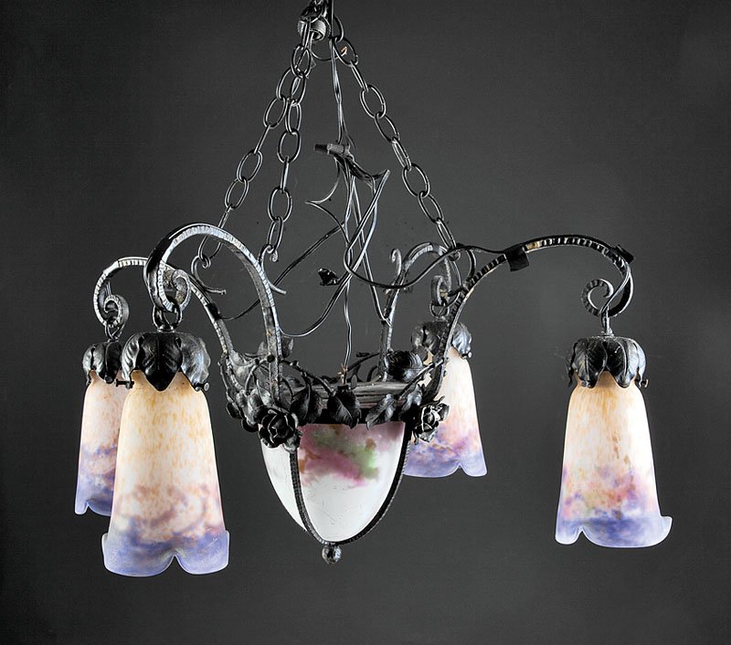 A French Art Deco Wrought Iron Four Light Chandel: A French Art Deco Wrought Iron Four Light Chandelier, early 20th c., Muller Freres a Luneville, scrolled supports, with ruffled shades, bell form central shade also illuminated, allover applied foliat