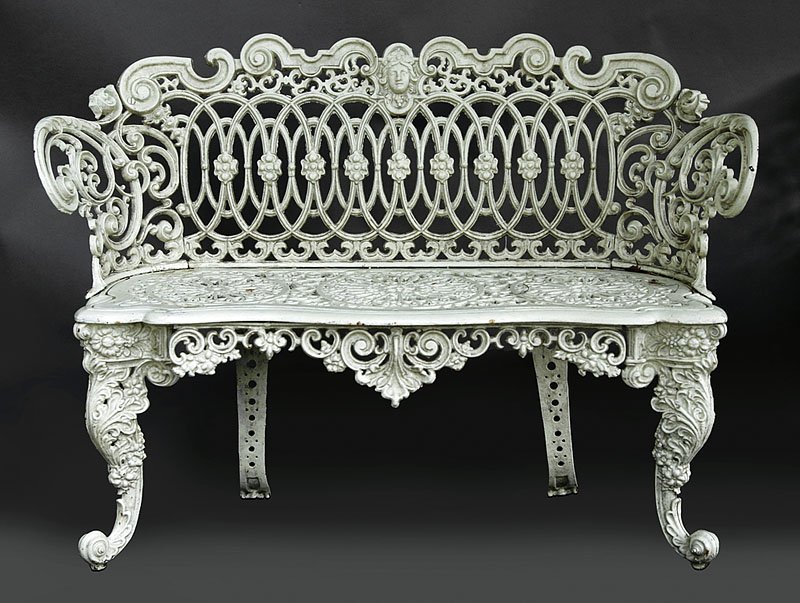 A Cast Iron Garden Suite: A Cast Iron Garden Suite, late 19th/early 20th c., comprised of a settee and pair of armchairs, each crest centered by a masque, interlaced scrolled design, cabriole legs. Note: Chairs with cast mark 