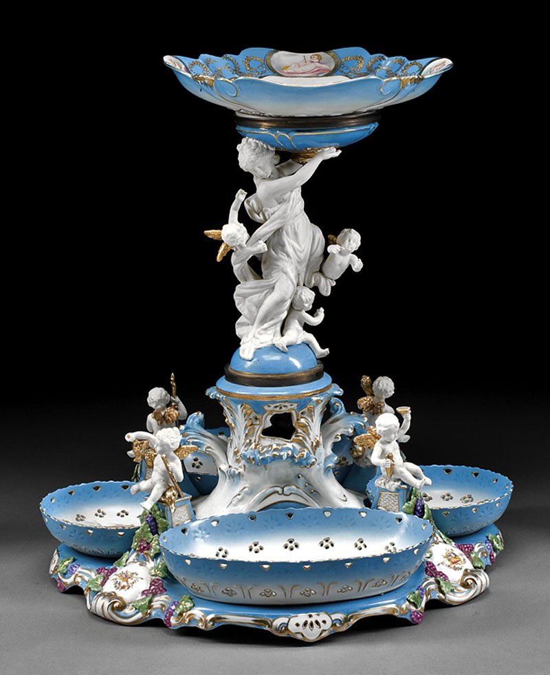 Polychrome and Gilt Porcelain Figural Centerpiece: A Monumental Sevres-Style Polychrome and Gilt Porcelain Figural Centerpiece, bears pseudo "Sevres" mark, shaped plate held aloft by classical-style female figure amid putti, scrolled foliate base set 