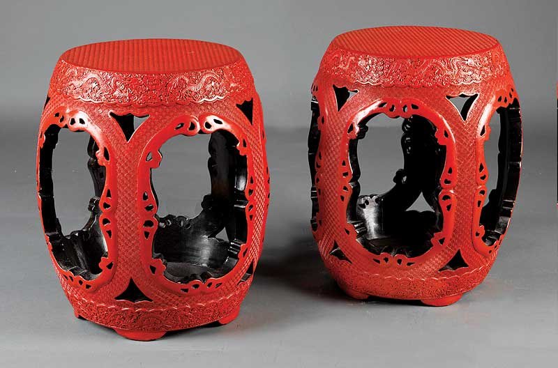 A Pair of Chinese Cinnabar Lacquer Garden Stools: A Pair of Chinese Cinnabar Lacquer Garden Stools, probably 20th c., barrel-form bodies carved with bands of dragons amid clouds on a fretwork ground, height 19 3/8 in., diameter 17 1/4 in