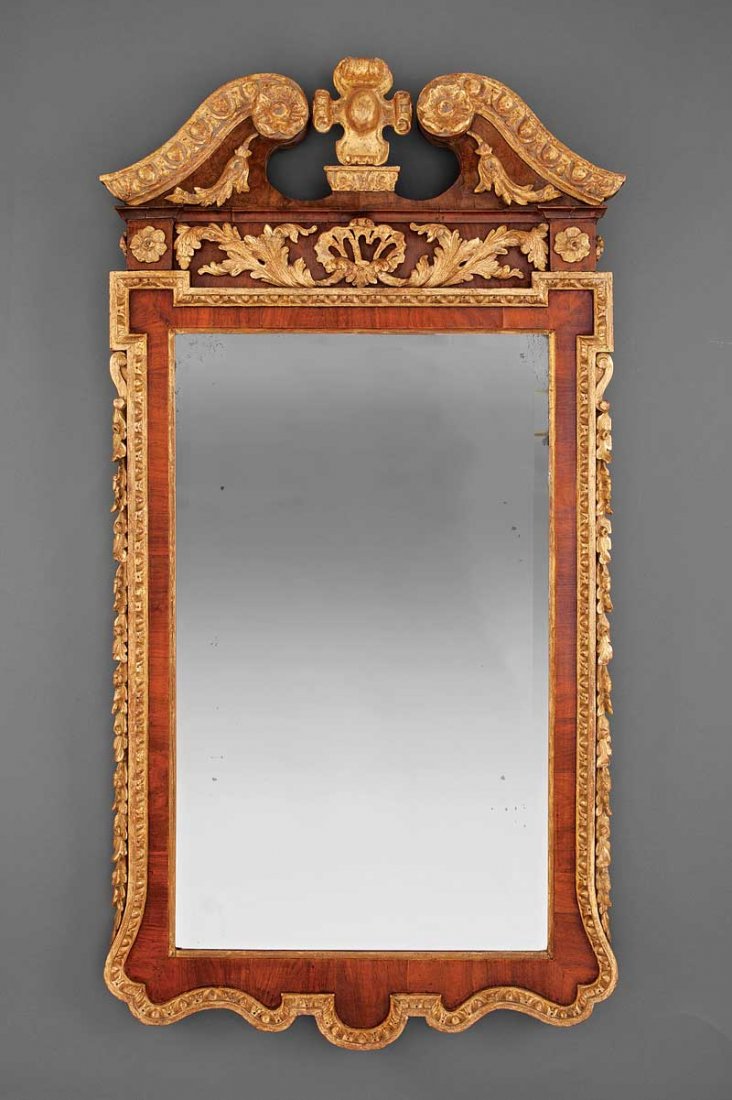 A George III Carved Walnut and Giltwood Mirror: A George III Carved Walnut and Giltwood Mirror, 18th c., broken arch molded crest centered by a cabochon, leaf and shell frieze, rosette corners, carved molded surround, height 50 in., width 26 in